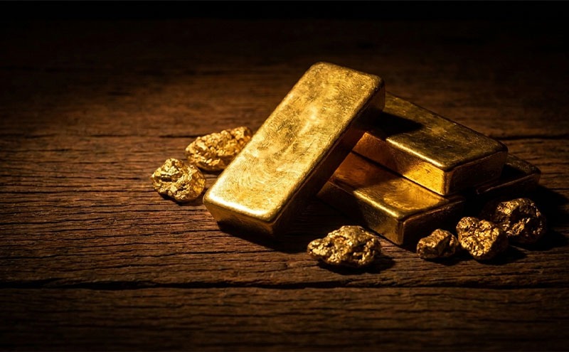 قطعات و شمشهای طلا روی میز چوبی